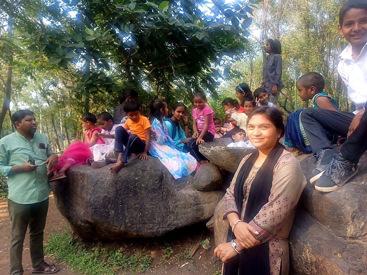 निसर्ग सहलीत दगडांवर बसलेली आश्रमातील मुले