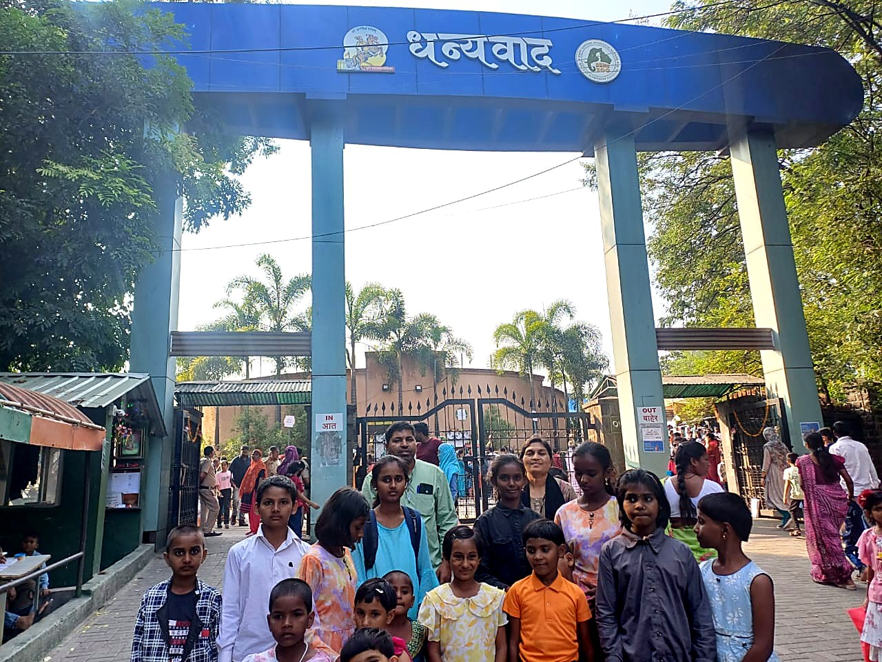प्राणिसंग्रहालयाच्या प्रवेशद्वारी मुले व सेवक