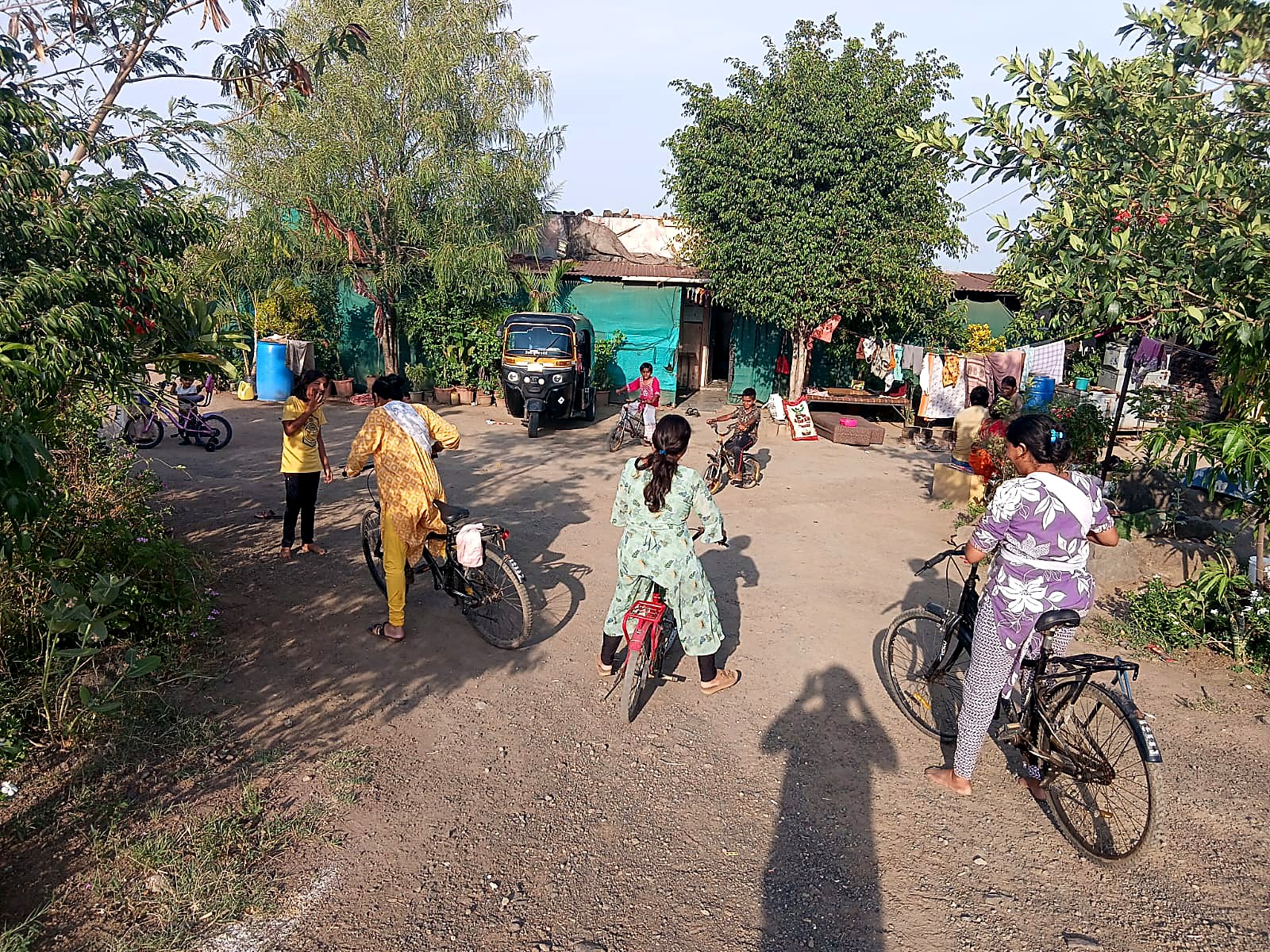 आश्रमाच्या अंगणात मुले सायकल शिकताना